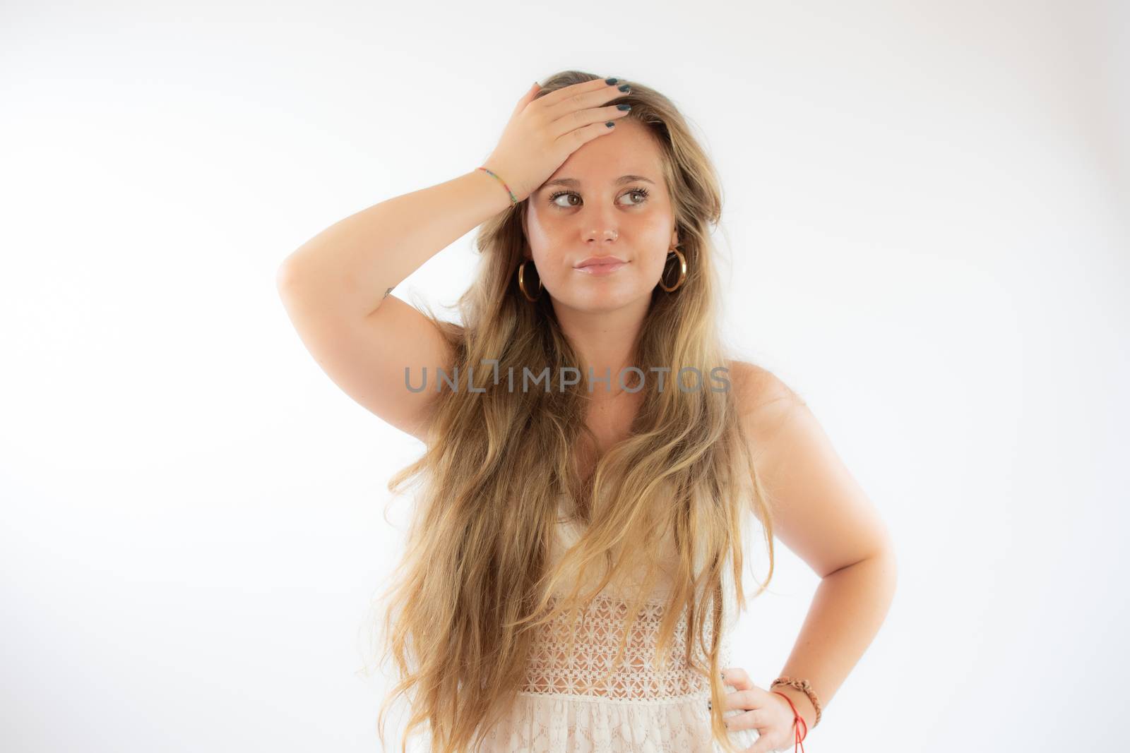 Pretty blonde girl in a white dress with the gesture of concern on her face