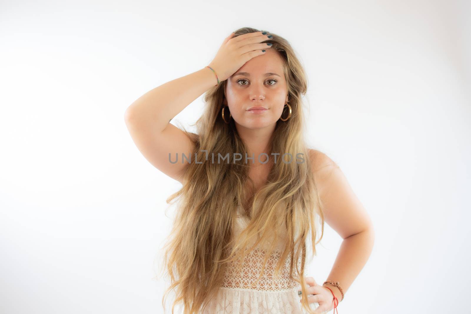 Pretty blonde girl in a white dress with the gesture of concern on her face