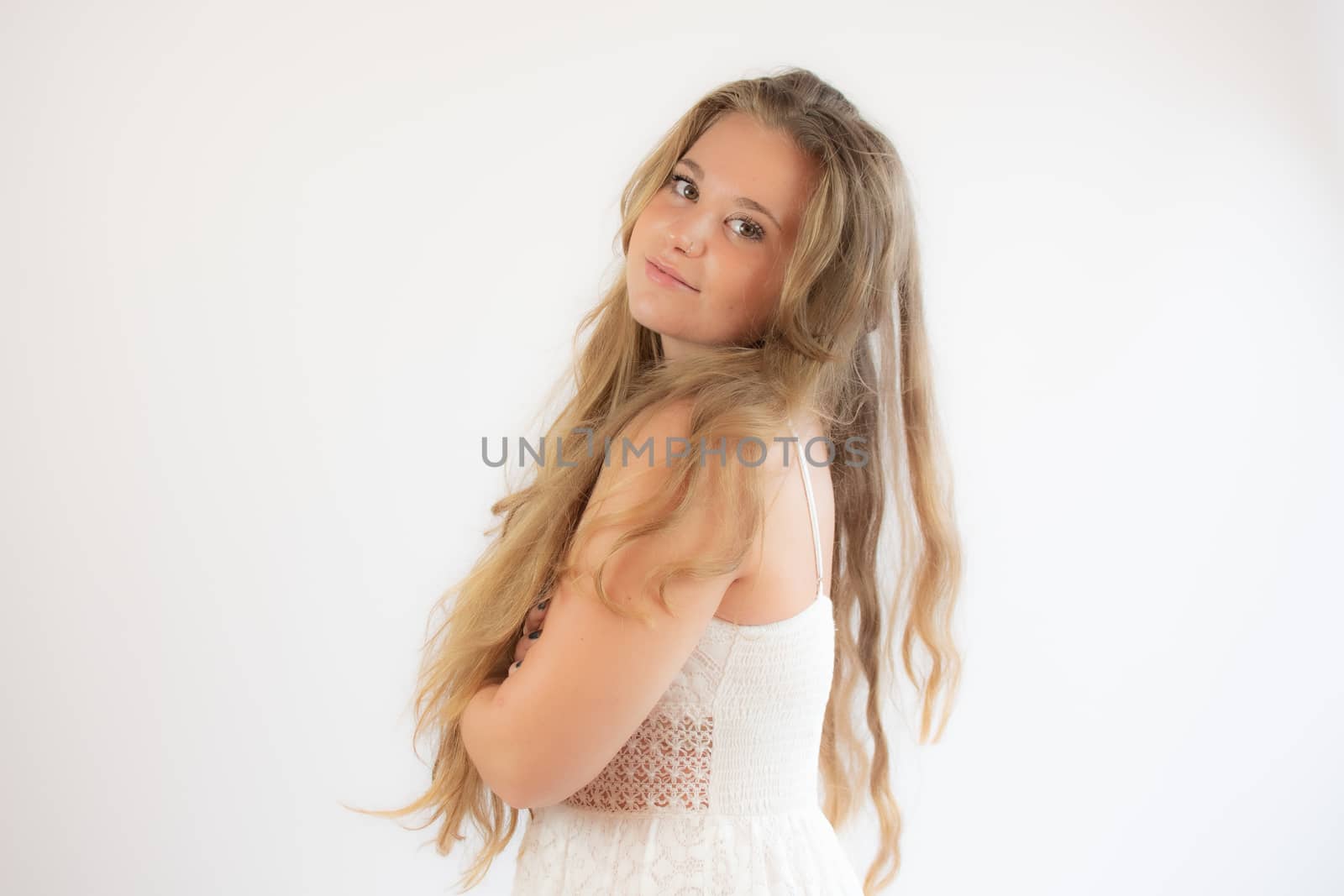 Portrait of a pretty blonde girl in a white dress