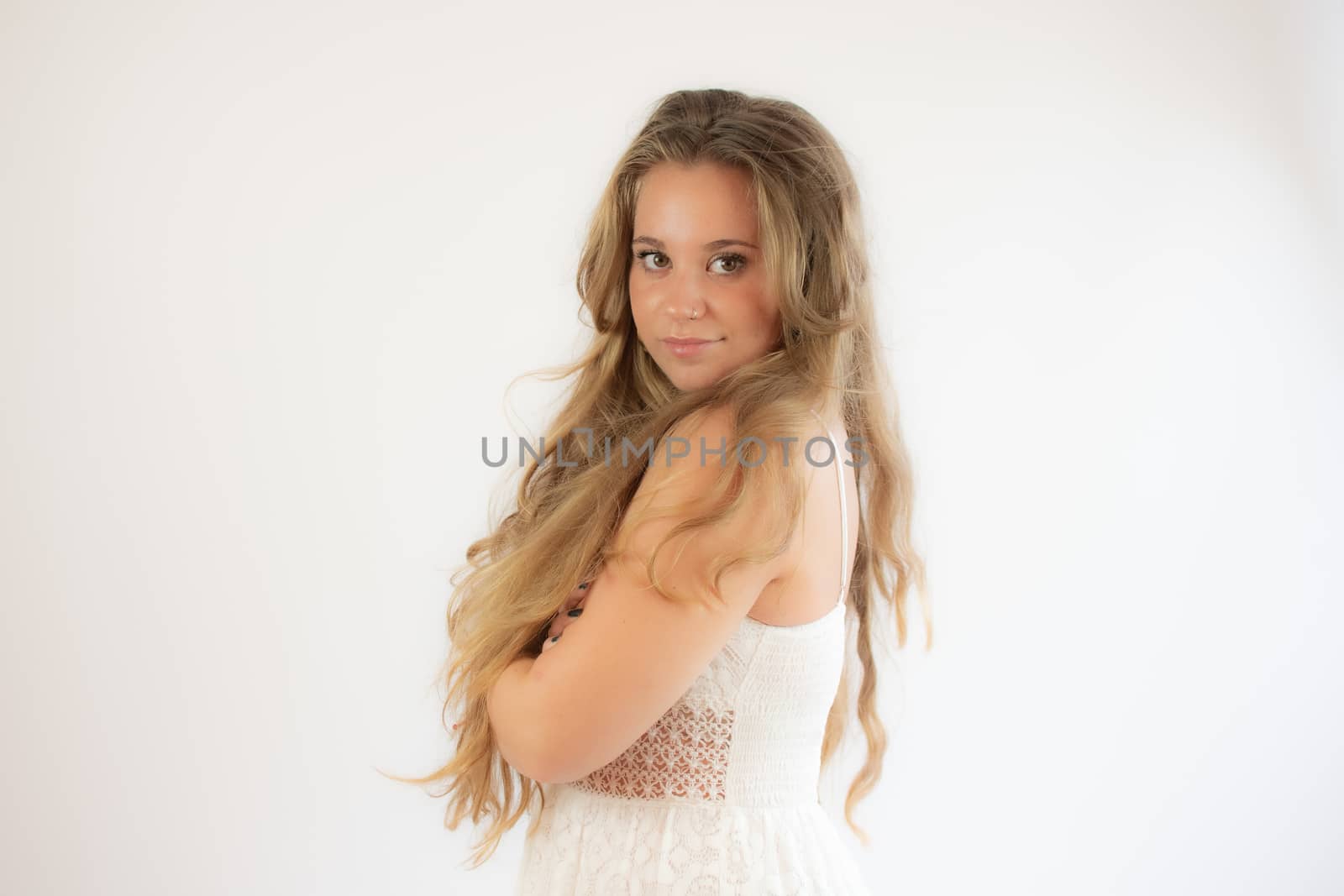 Portrait of a pretty blonde girl in a white dress