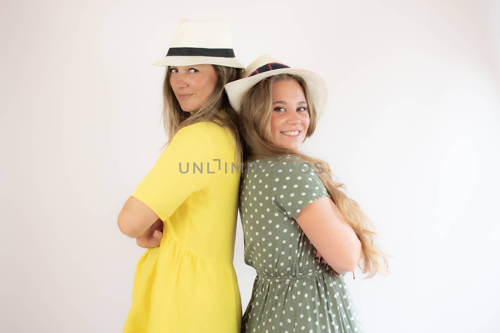 Two smiling girls in hat with cheerful gesture