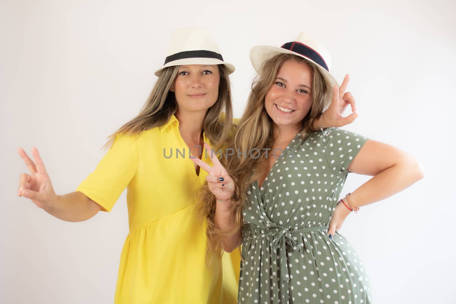 Two smiling girls in hat with cheerful gesture