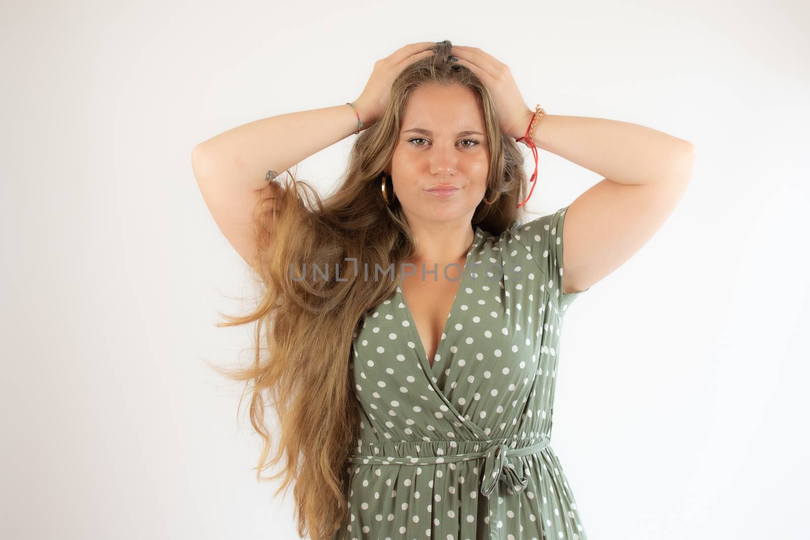 Pretty blonde girl in a green dress with the gesture of concern