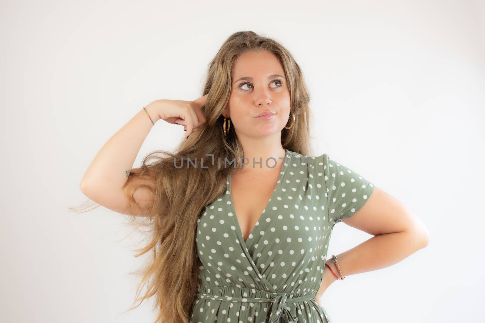 Pretty blonde girl in a green dress with the gesture of concern