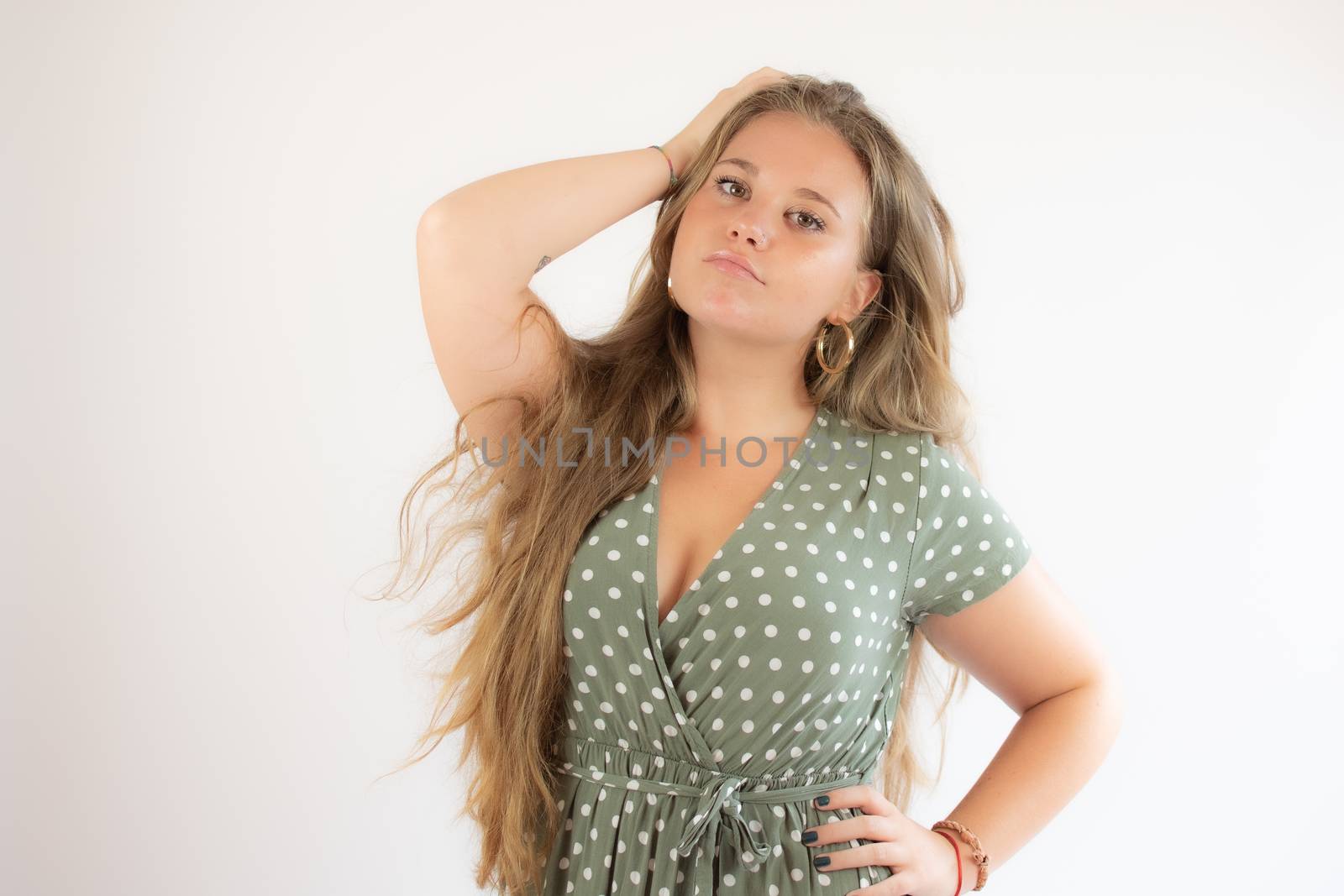 Pretty blonde girl in a green dress with the gesture of concern