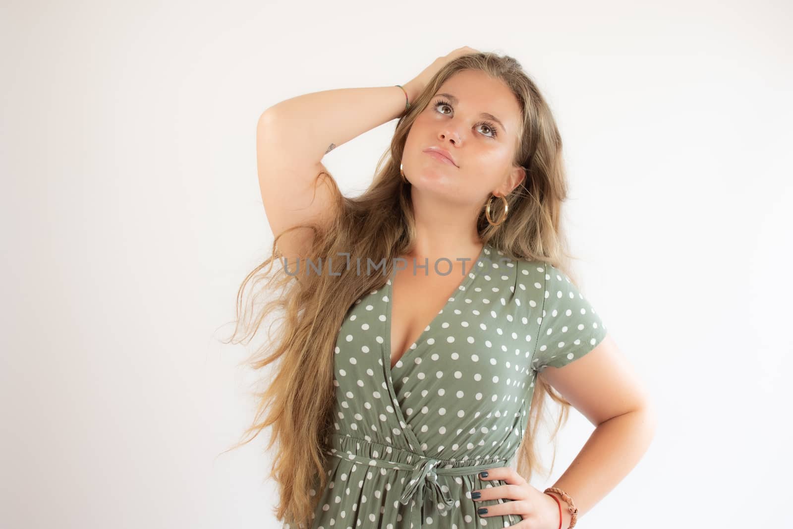 Pretty blonde girl in a green dress with the gesture of concern