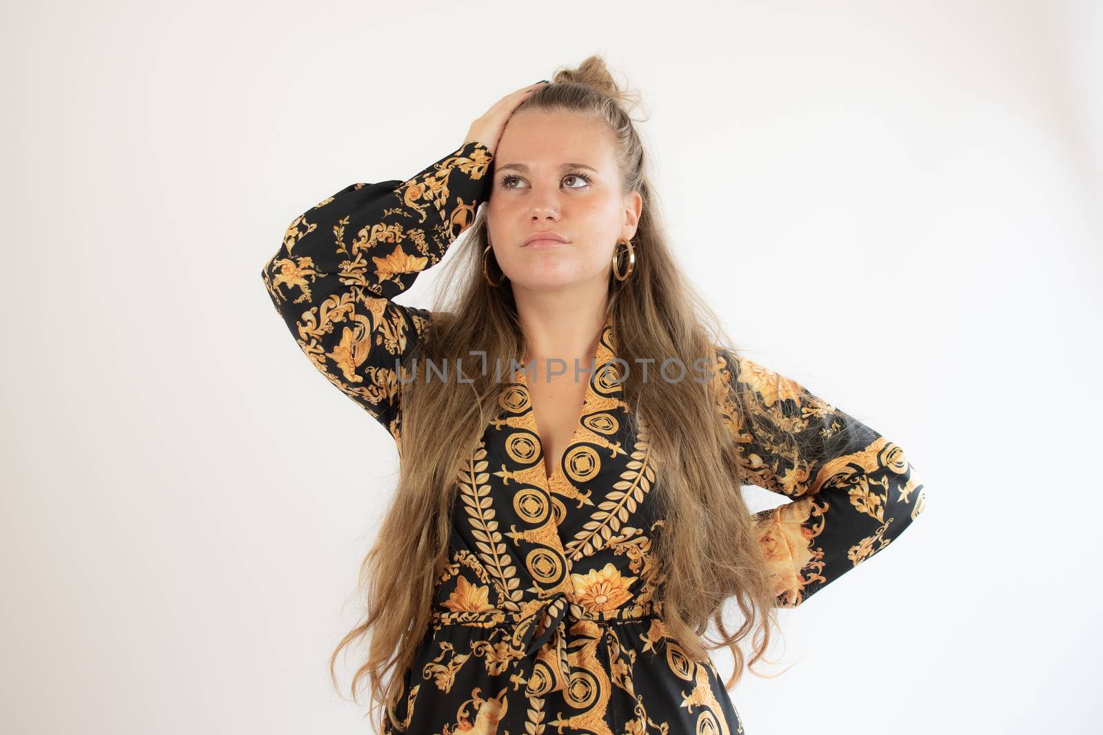 Pretty blonde girl in black gold dress thoughtful