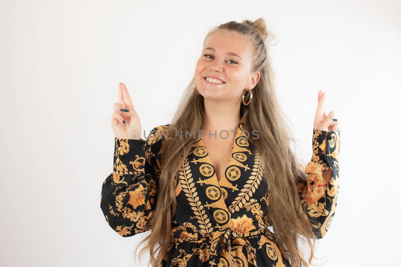 Pretty blonde girl in black gold dress with fingers crossed