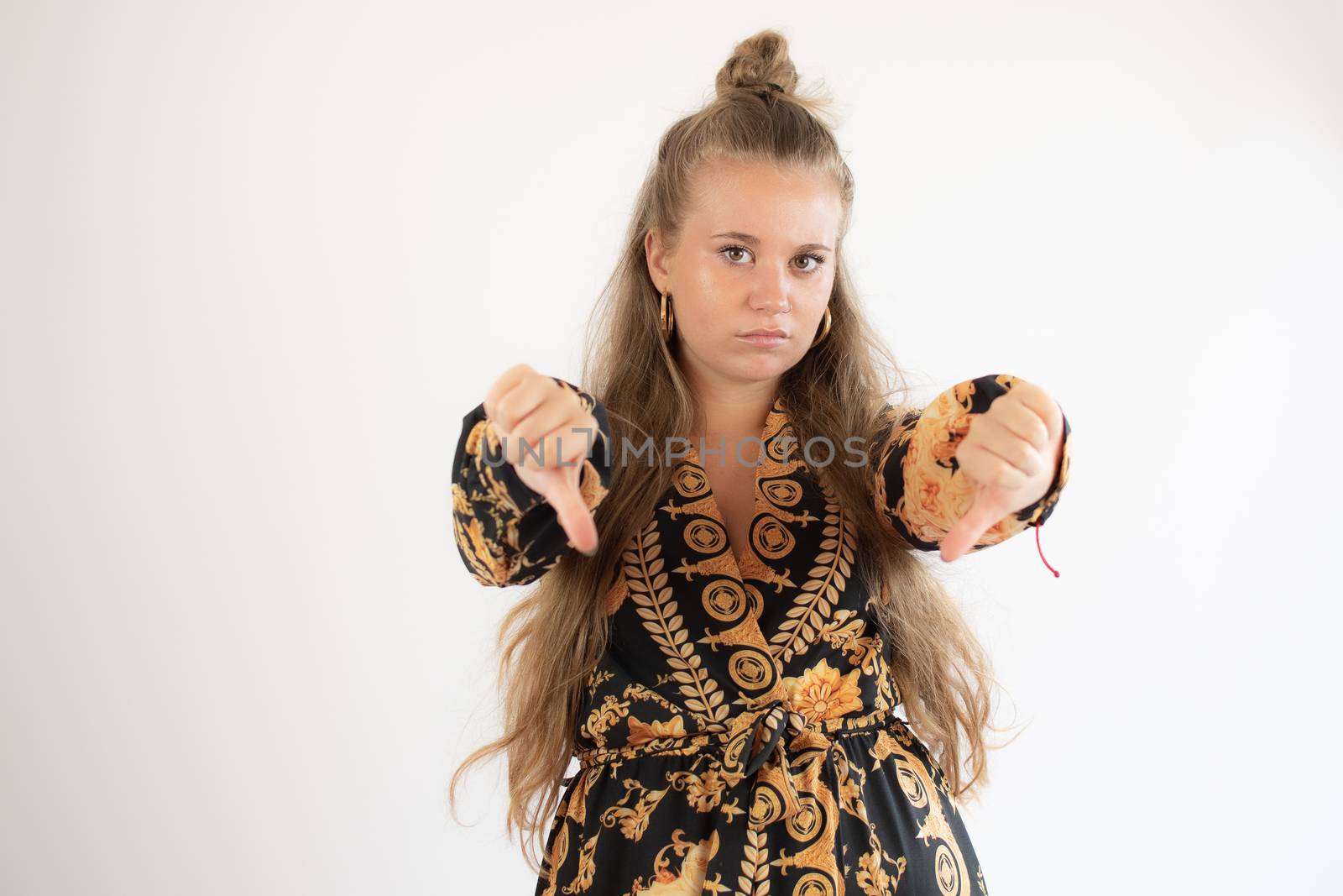 Pretty young girl in black dress making fingers down gesture