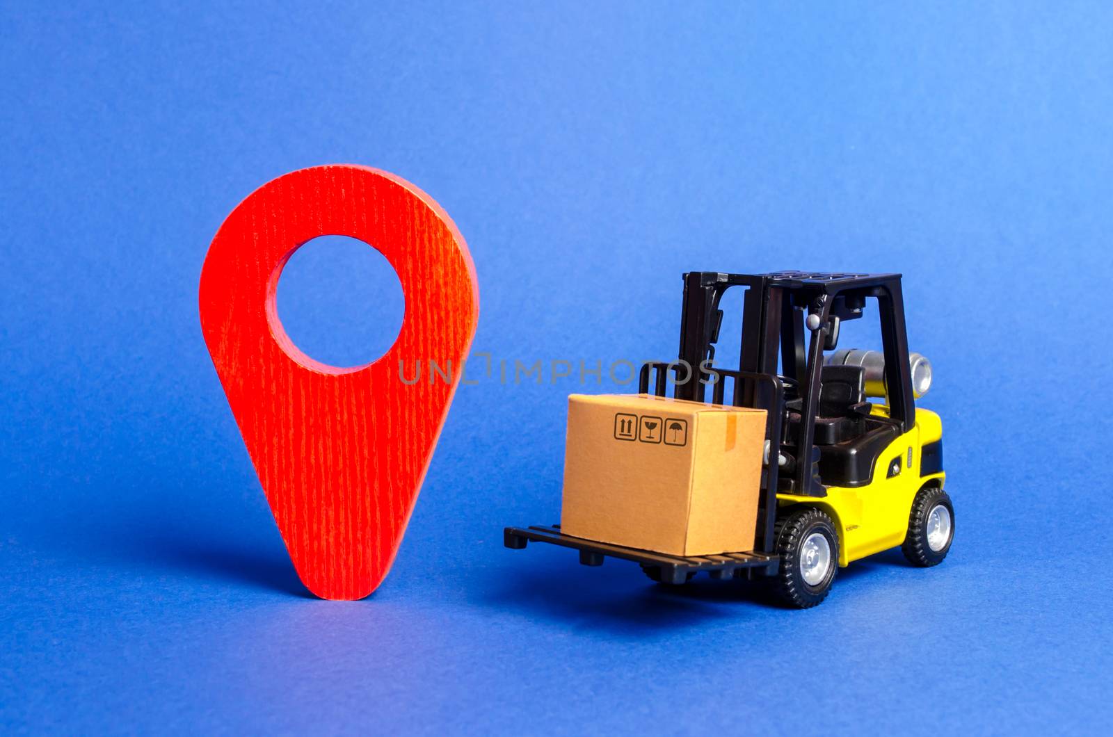 Yellow Forklift truck carries a box next to red pointer location. Services transportation of goods, products, logistics and infrastructure. Transportation company. Location of carriers tracking