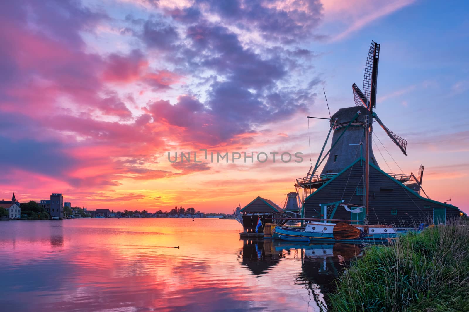 Netherlands rural scene - - windmills at famous tourist site Zaanse Schans in Holland on sunset with dramatic sky. Zaandam, Netherlands