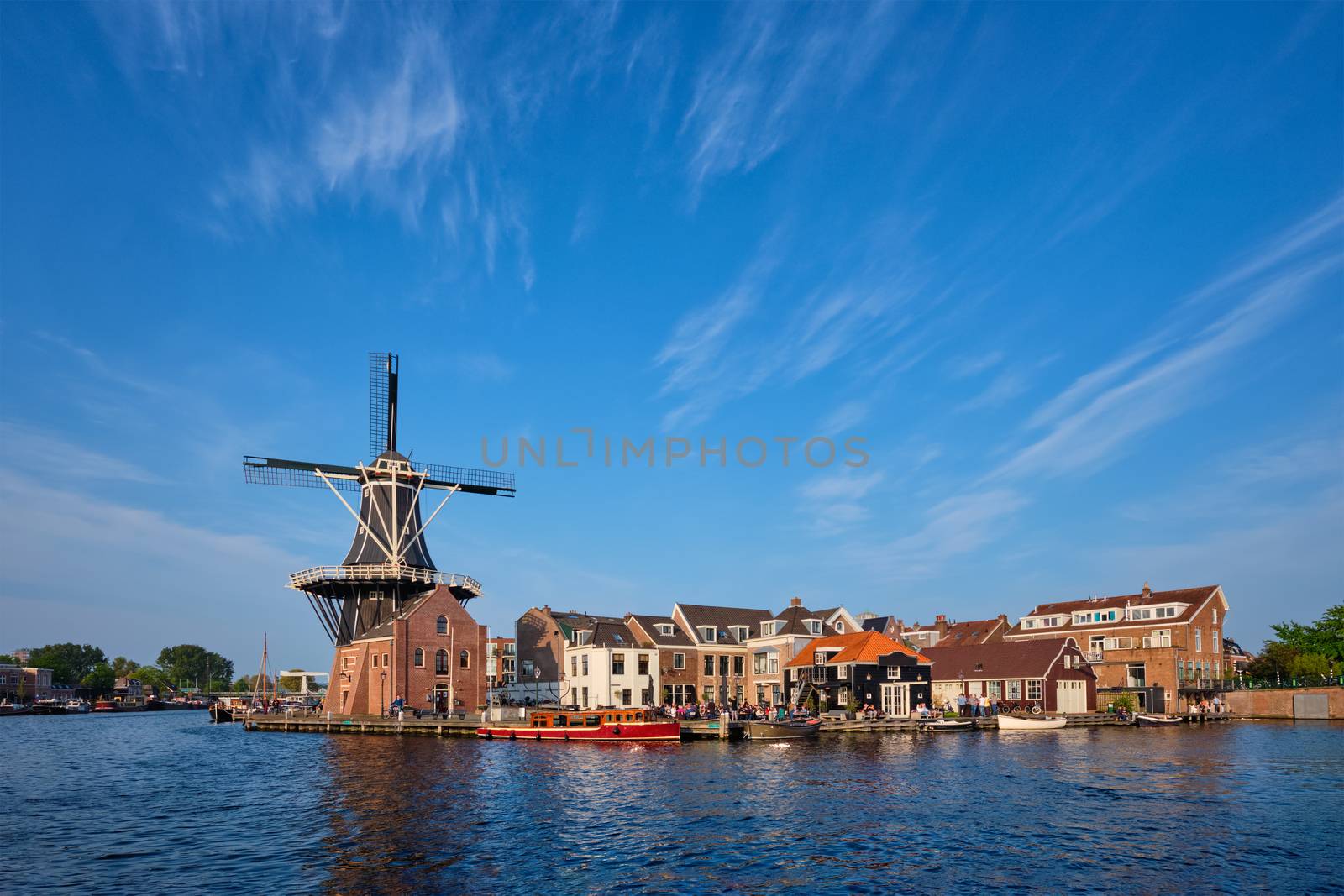 Harlem cityscape - landmark windmill De Adriaan on Spaarne river with boats. Harlem, Netherlands