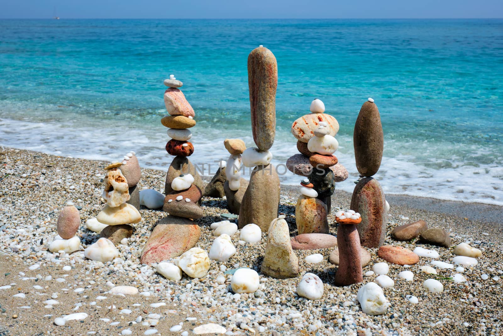 Concept of zen balance relaxation peace and harmony. Pebbles stacks on the beach coast of the blue sea in the nature. Meditative art of stone stacking.