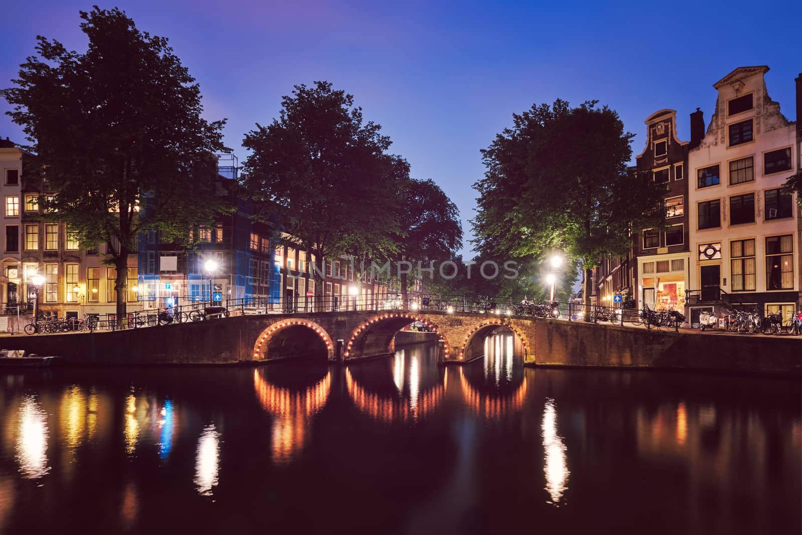 Amterdam canal, bridge and medieval houses in the evening by dimol