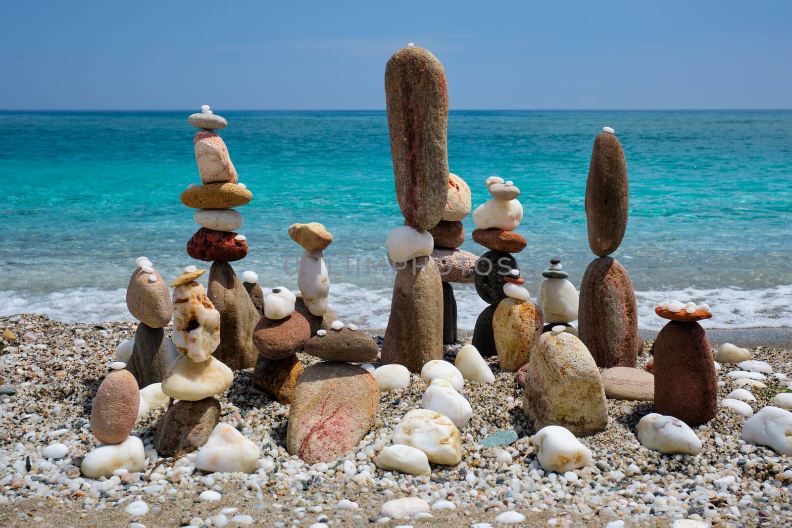Concept of balance and harmony. Stones pebbles stacks on the beach coast of the blue sea in the nature. Meditative art of stone stacking.