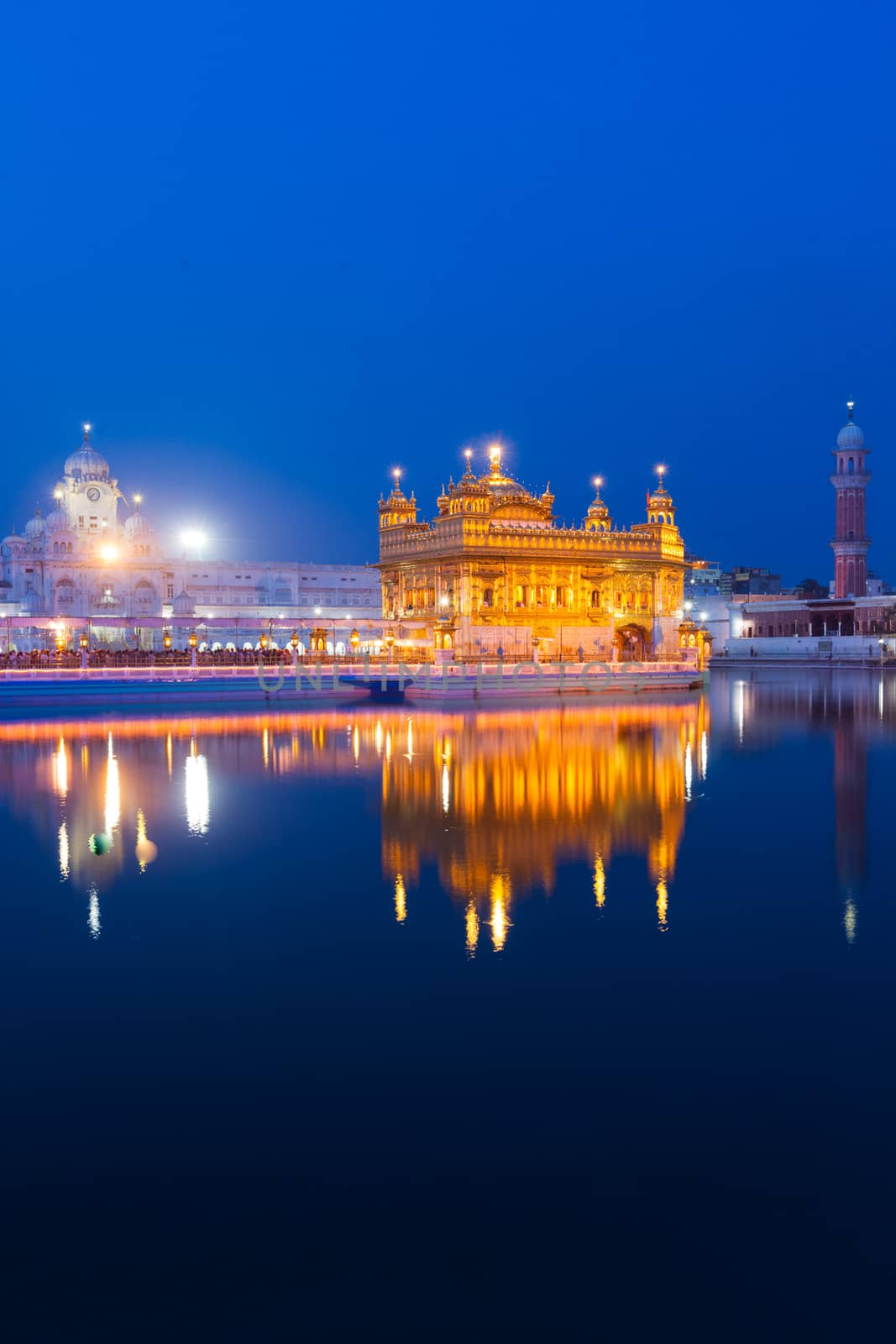 Sikh sacred site gurdwara Sri Harmandir Sahib (also known as The Golden Temple, also Darbar Sahib) illuminated at night. Amritsar, Punjab state, India