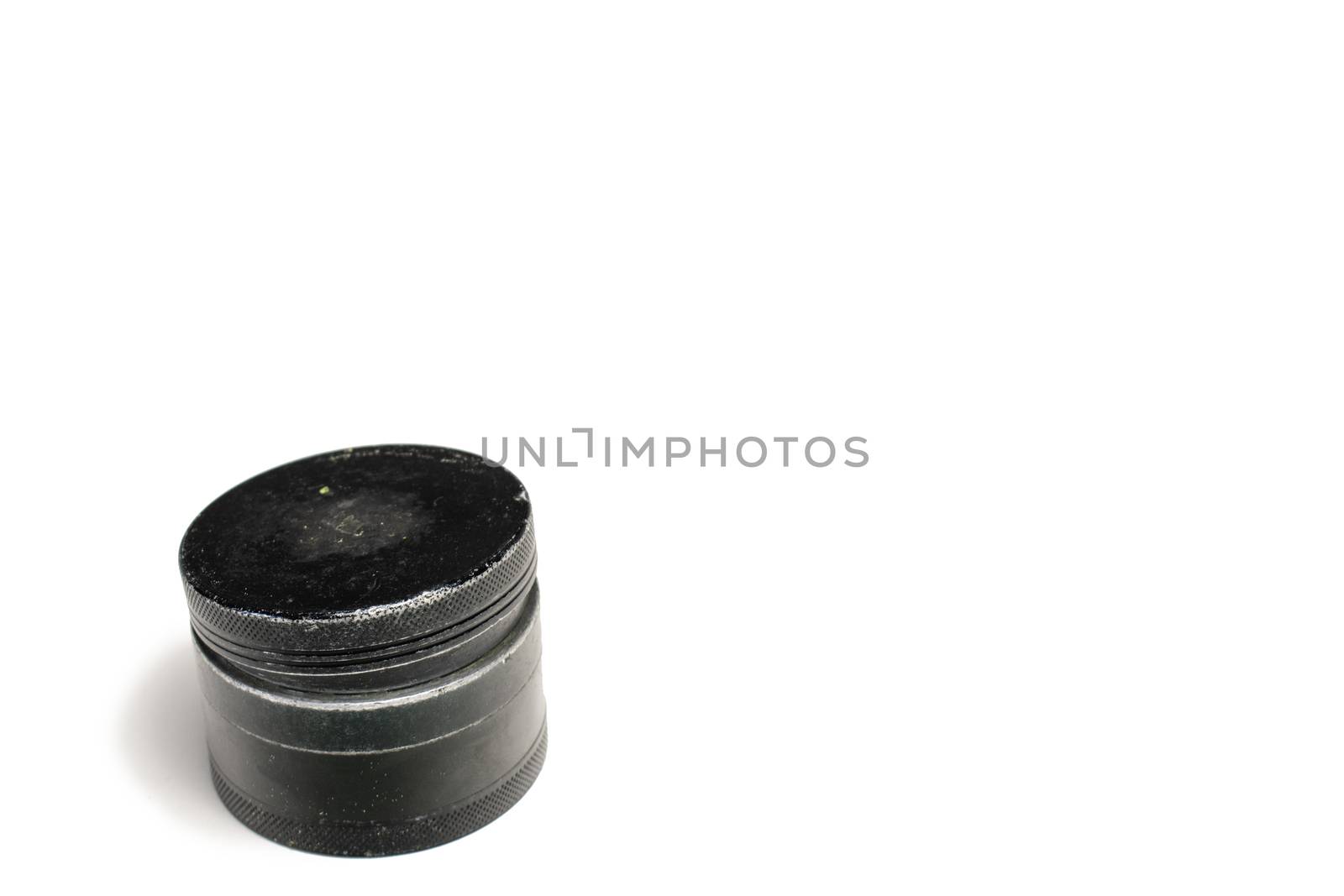 A Black and Used Marijuana Grinder With the Lid Losely Closed