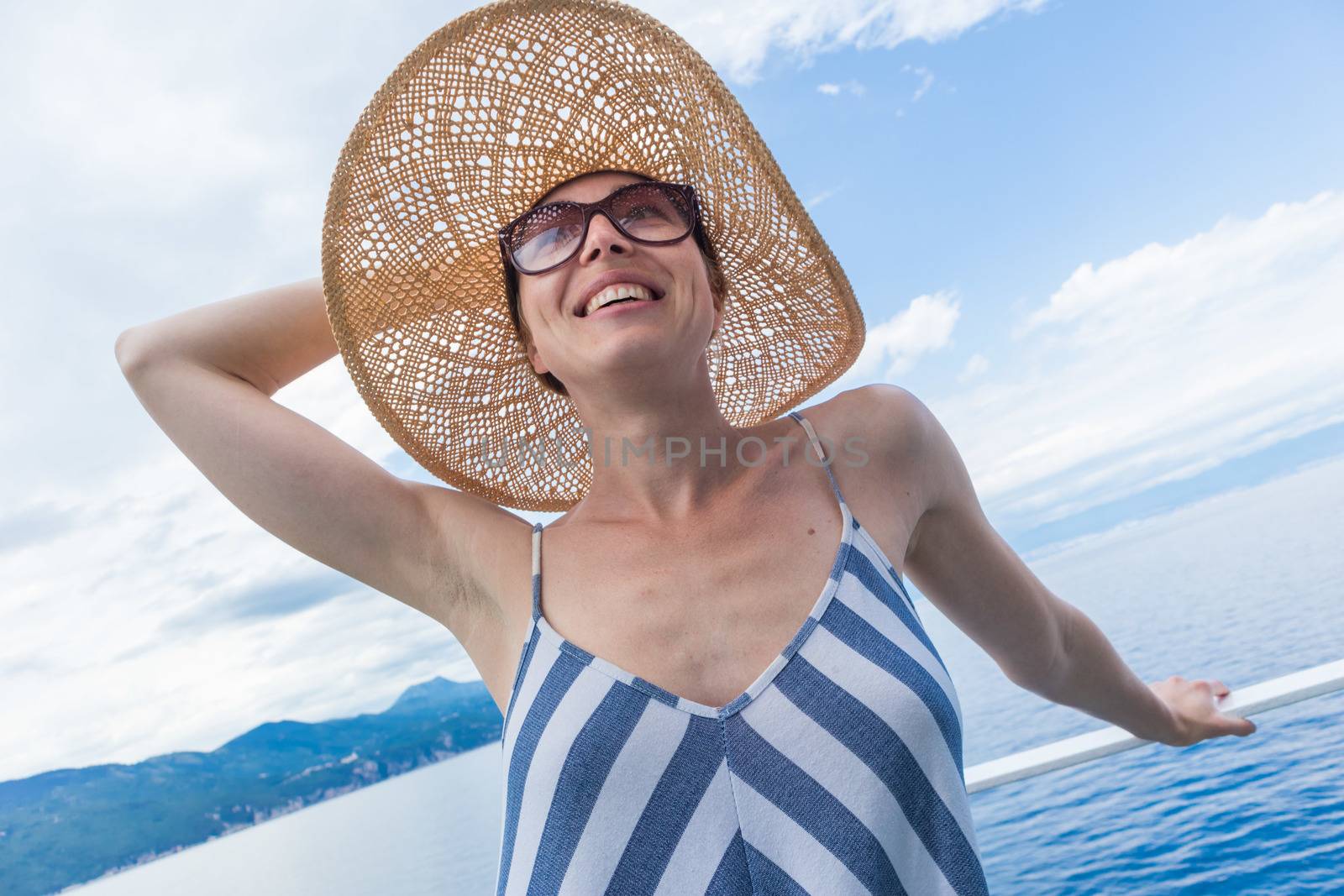 Beautiful, romantic blonde woman relaxeing on summer vacations traveling by cruse ship ferry boat. Summer vacation lifestyle.