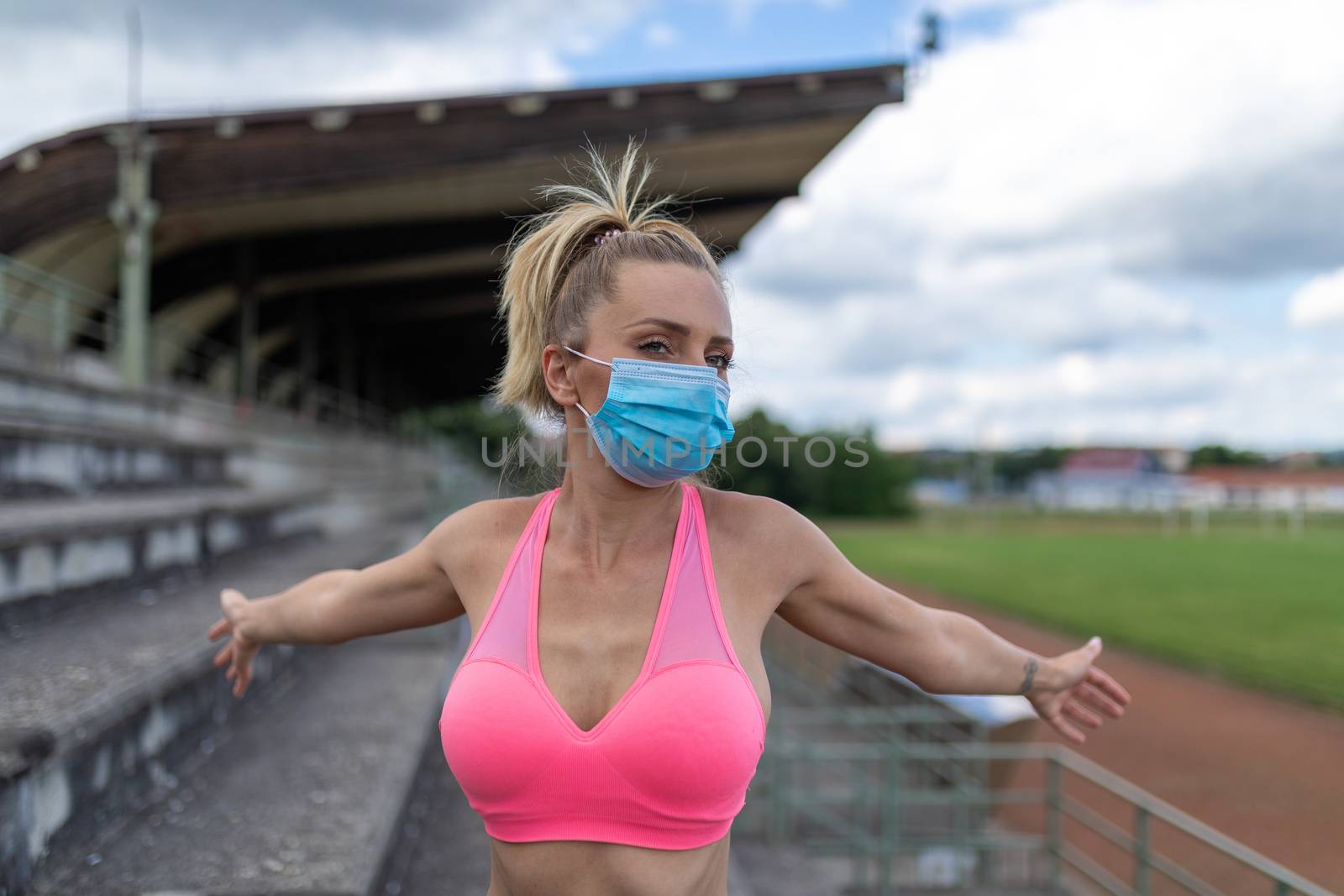Woman takes off medical facemask after outdoor training or runni by adamr