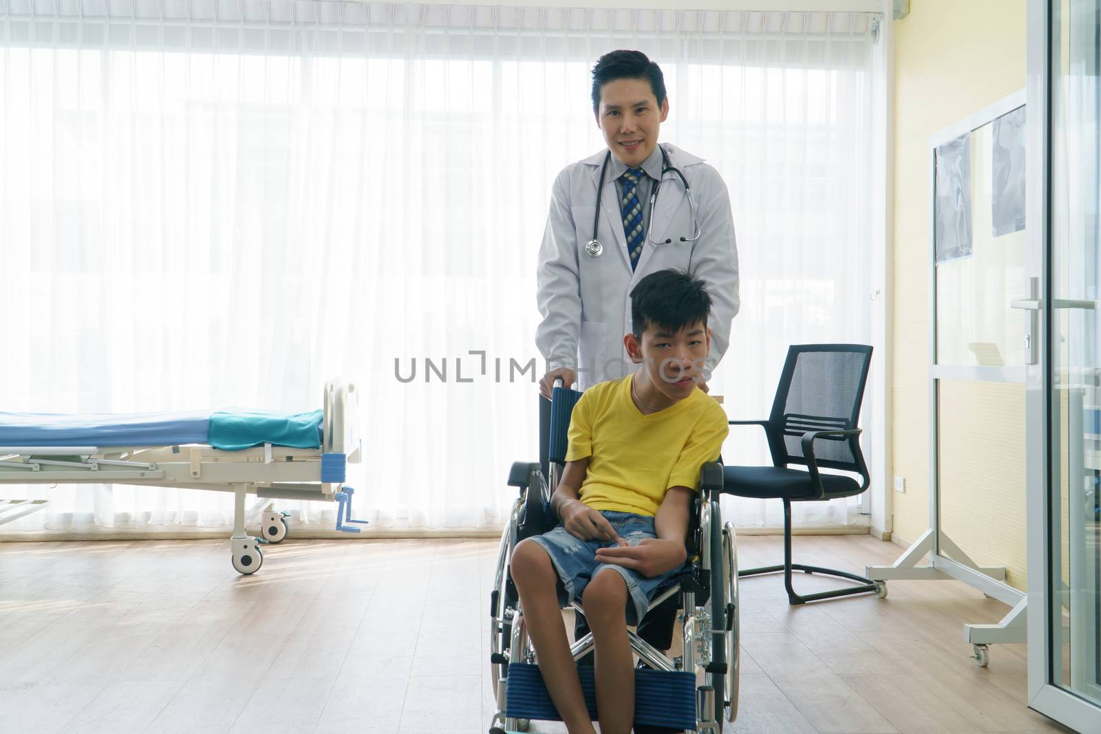 Asian doctors, adult men talking to patients with boy disabled in wheelchairs. Counseling and rehabilitation in disability in hospitals. Technology and modern medical science