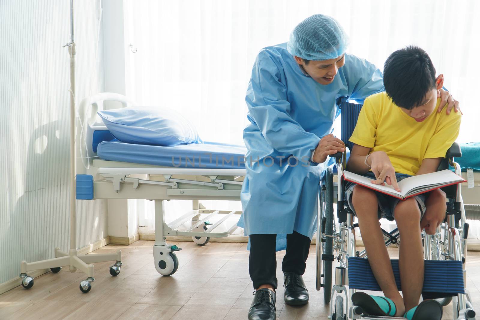 Asian doctors, adult men talking to patients with boy disabled in wheelchairs. Counseling and rehabilitation in disability in hospitals. Technology and modern medical science