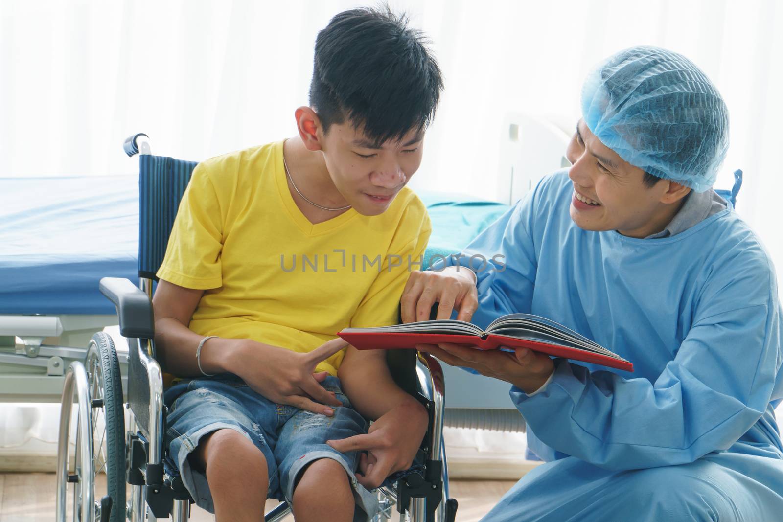 Asian doctors, adult men talking to patients with boy disabled in wheelchairs. Counseling and rehabilitation in disability in hospitals. Technology and modern medical science