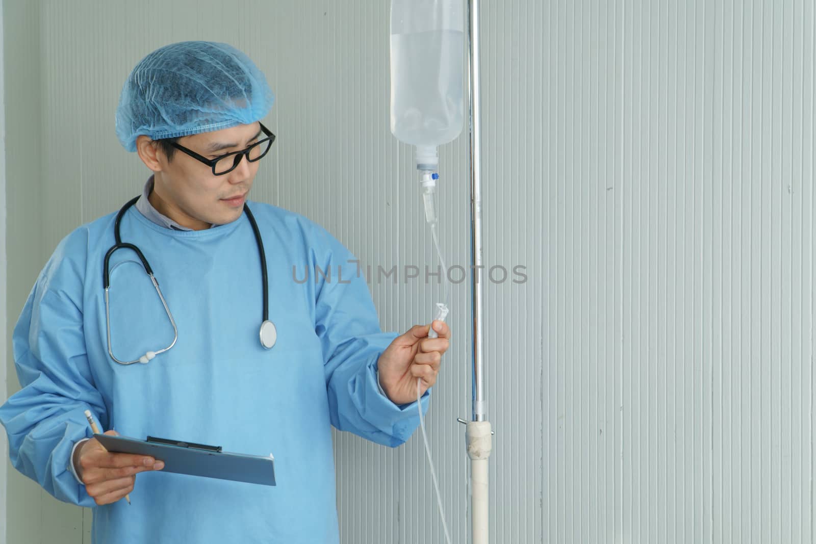 Portrait of a professional surgeon, an Asian man carrying a saline bag, operating in an emergency room. Modern medical technology and science. Concepts of care and rehabilitation in hospital patients.
