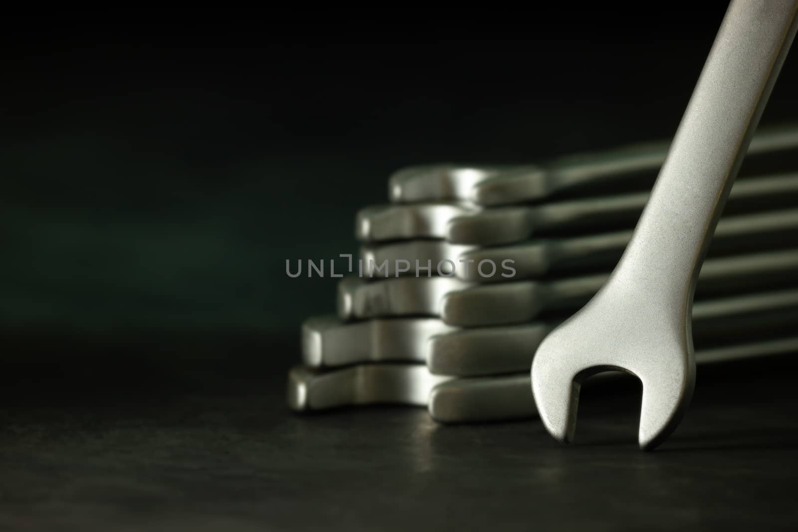 Wrench stacking on cement floor in darkness. Closeup and copy space for text. Concept of mechanical engineering jobs.