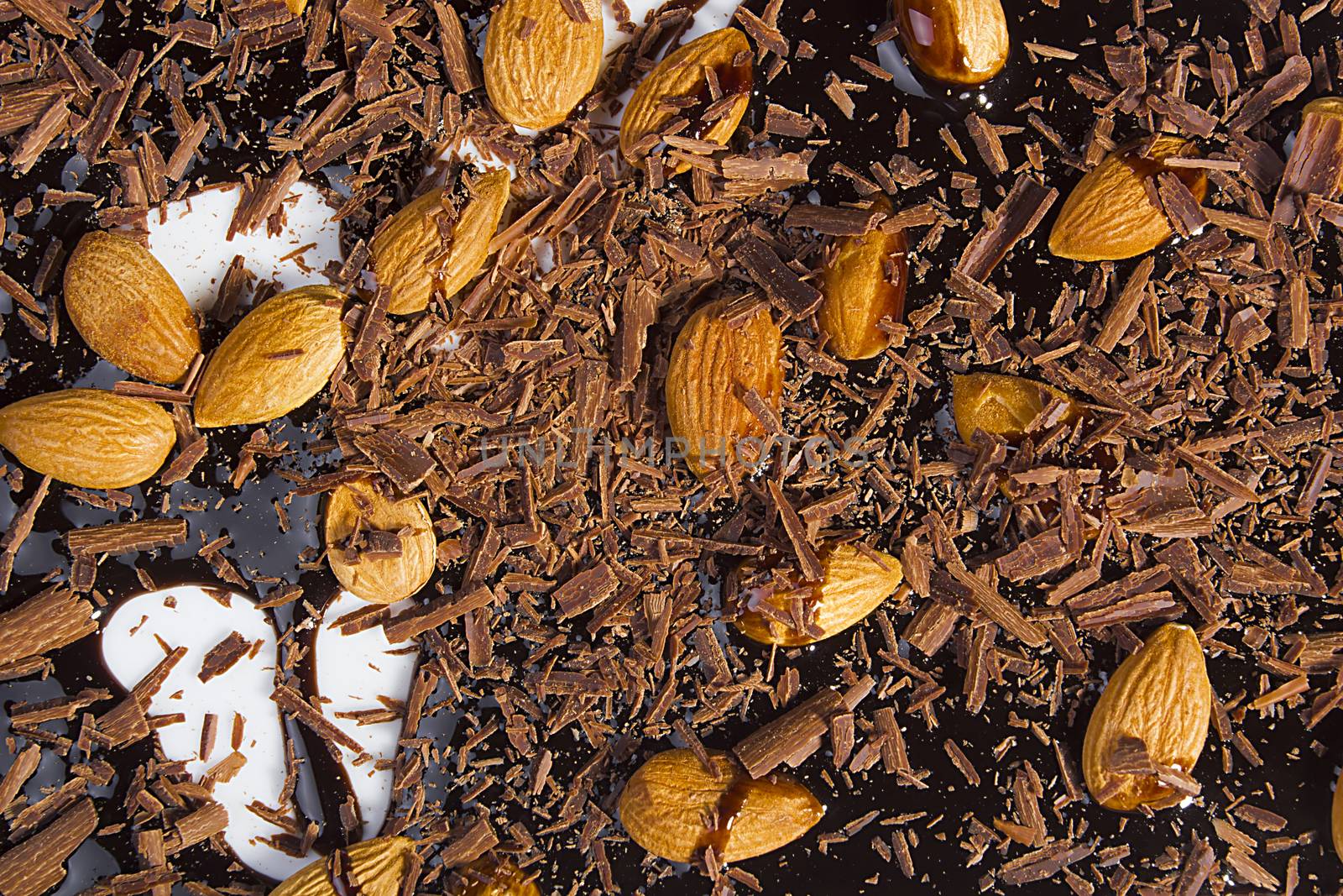 Almonds, grated and liquid chocolate on a white background