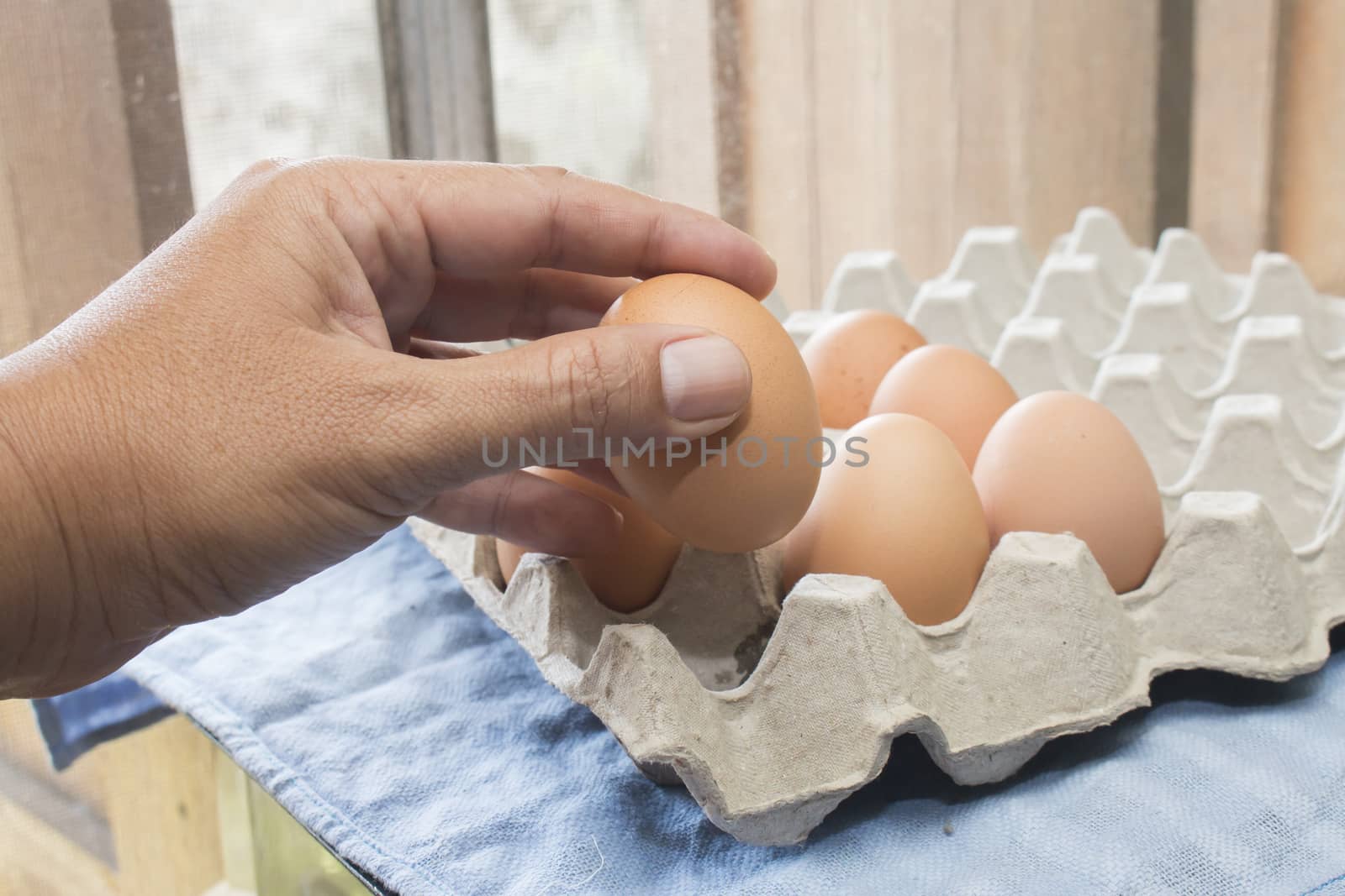 Man hand holding egg in kitchen