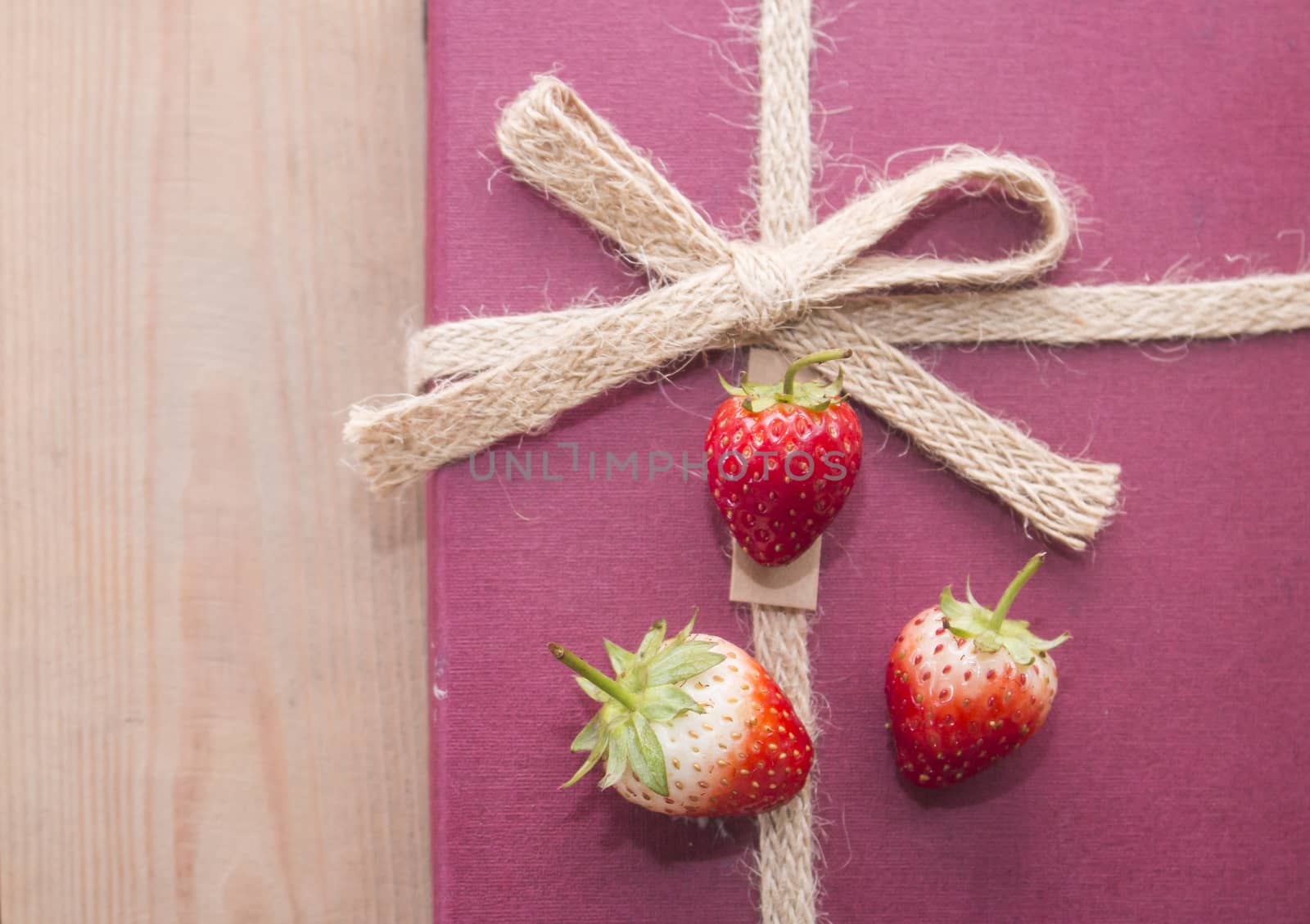 Three strawberries on gift box