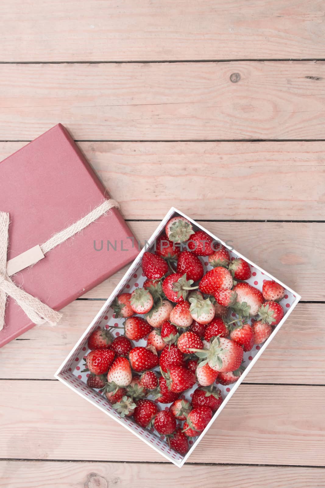 Fresh strawberries in gift box on wooden background