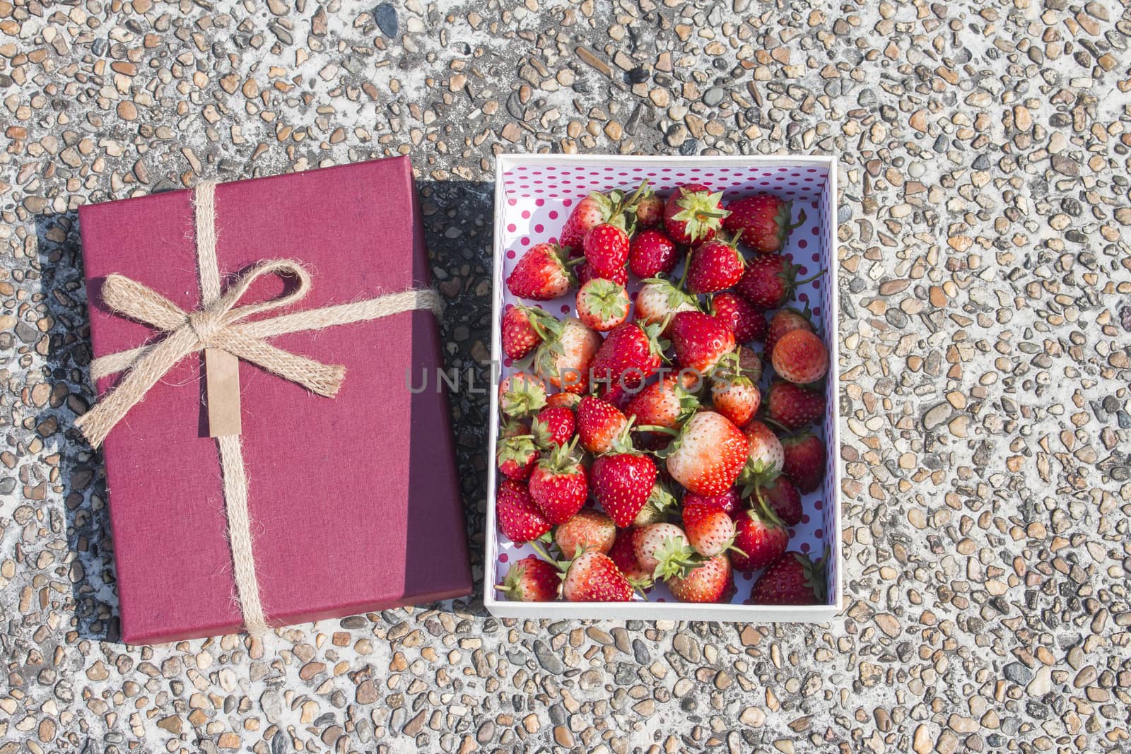 Fresh strawberrys in gift box on stone background