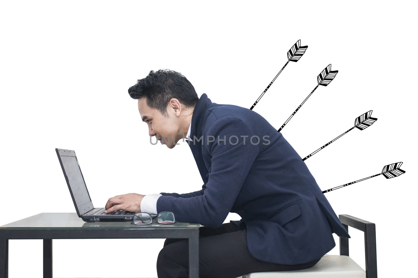 Asian Businessman sitting at a desk using a laptop with arrow stabbing his back,Business concept