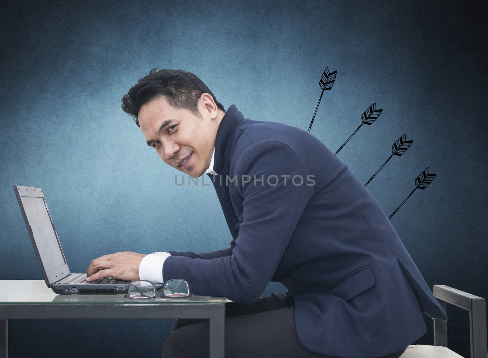 Portrait of young man sitting working on laptop  at his desk on white background,Persistence Concept. 
A man is working harder to achieve new sales target.