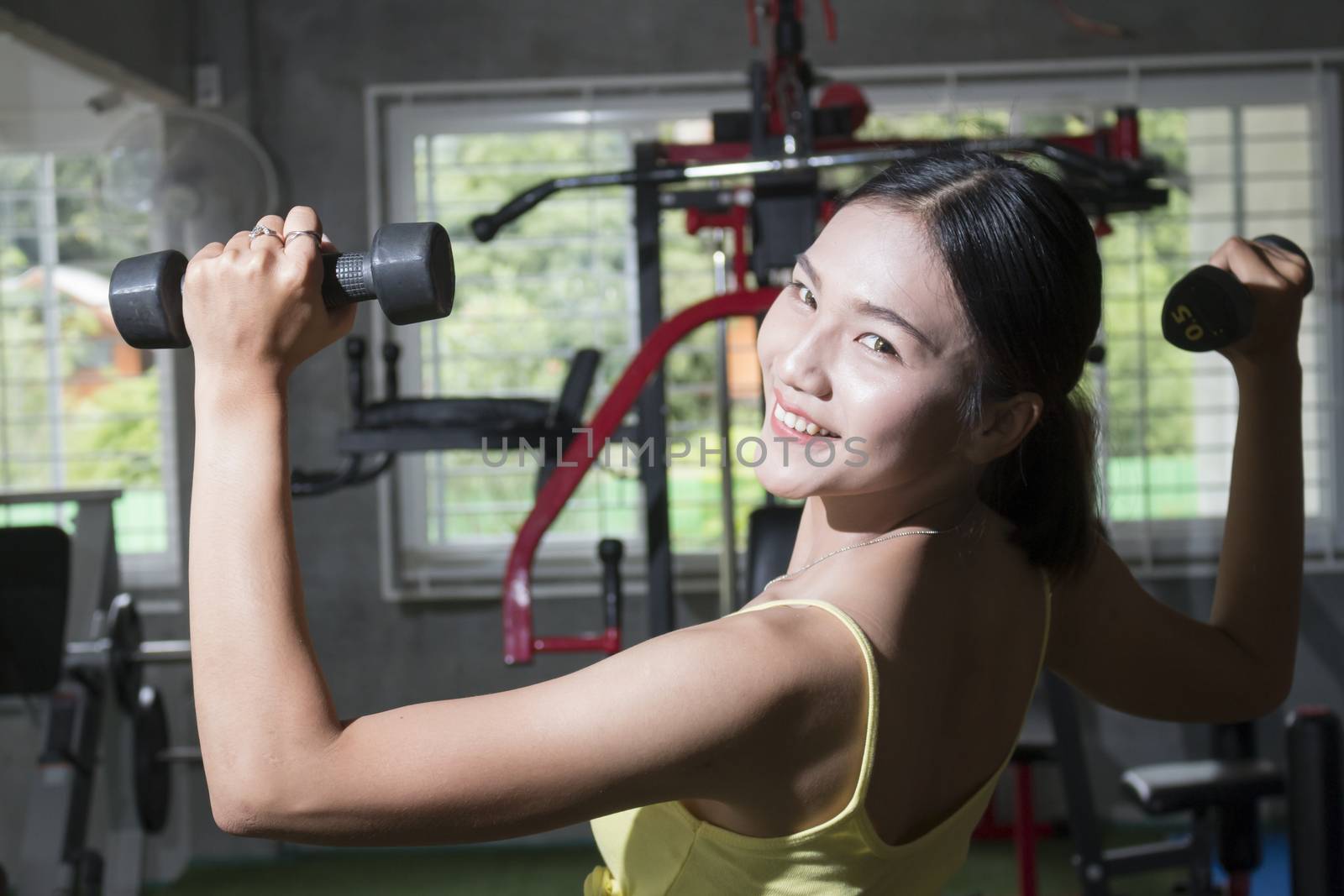 Smiling asian woman holding dumbell, healthy concept, sport