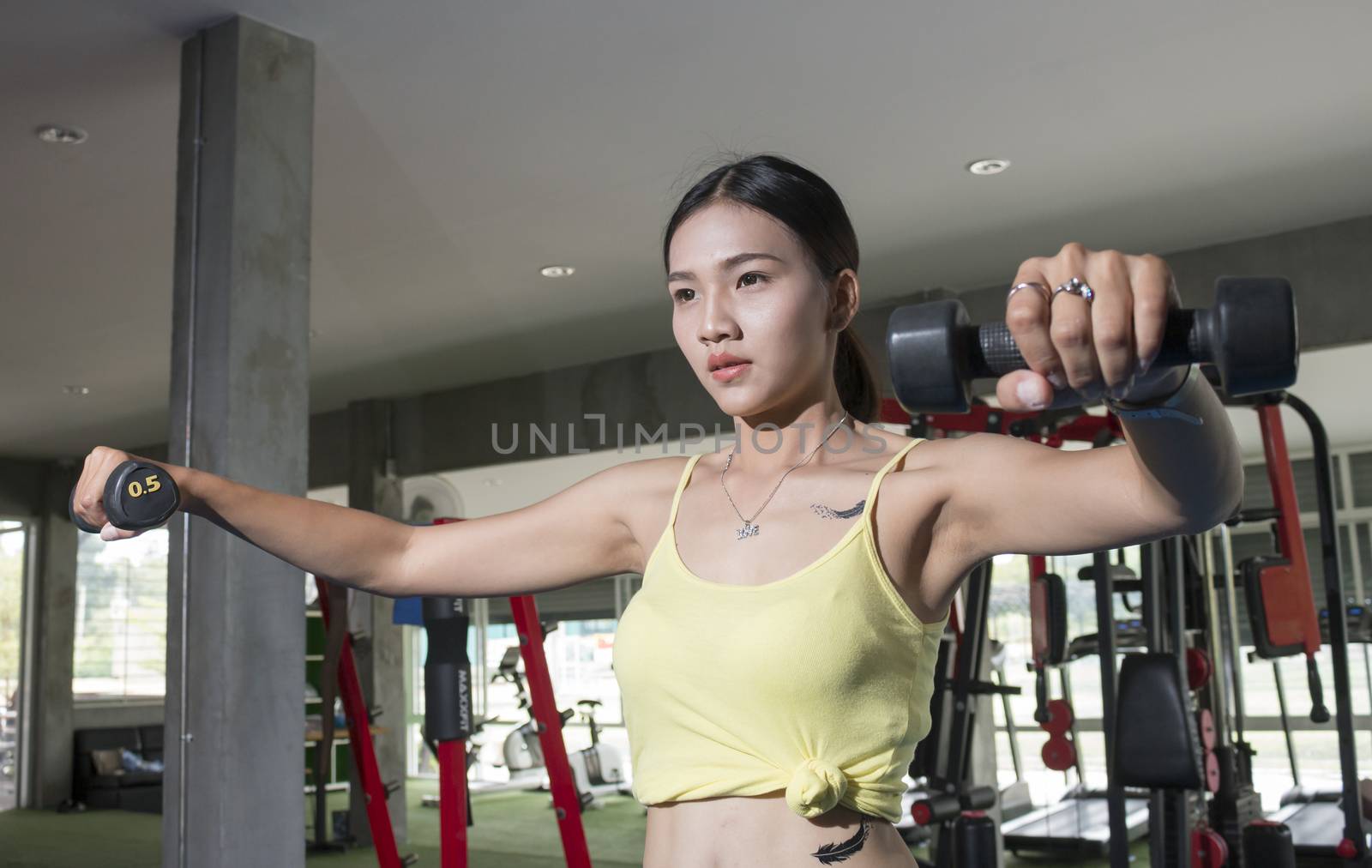 Asian sport women with dumbell in gym