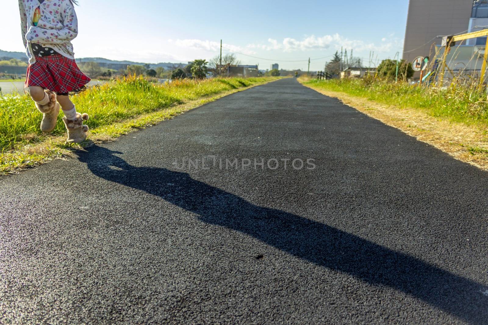 Girl running on a straight road by Umbrella