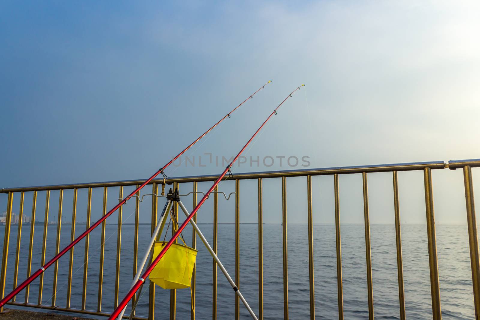 Fishing rods on the water. by Umbrella