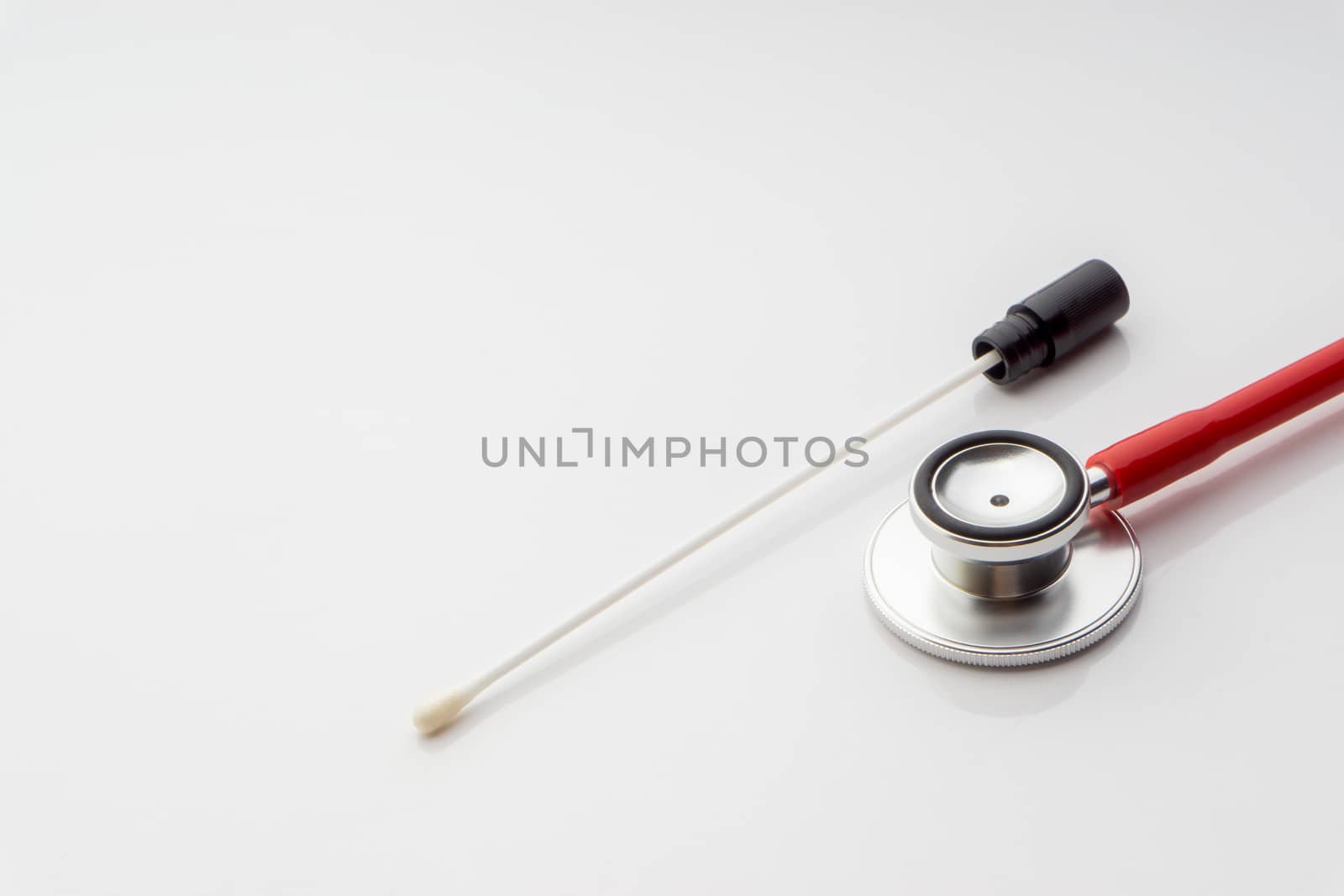 Medical swab and stethoscope on white background by silverwings