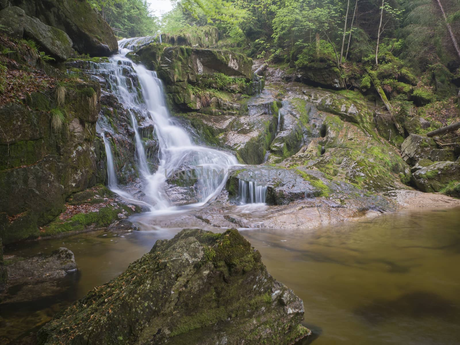 long exposure waterfall Poledni vodopad in Jizerske hory Jizera mountain, forest on Cerny potok black creek in czech republic, green mossed stones and ferns