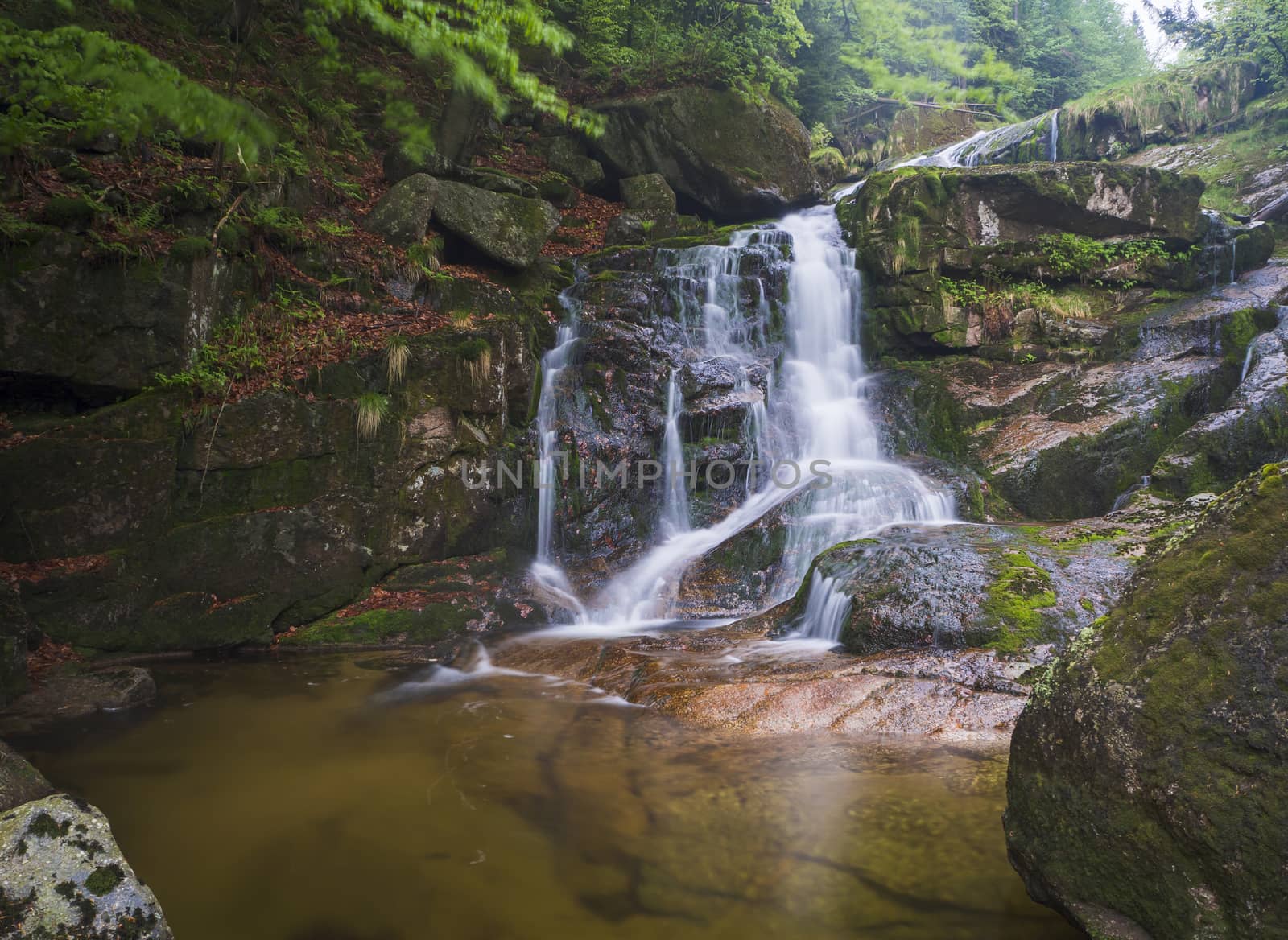 long exposure waterfall Poledni vodopad in Jizerske hory mountain forest on Cerny potok black creek in czech republic, green mossed stones and ferns by Henkeova