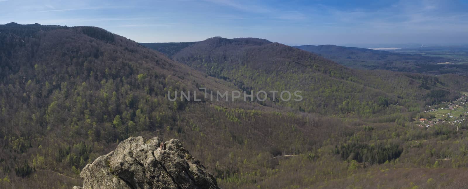 Panoramic landscape of Jizera Mountains jizerske hory, view from peak oresnik mountain with lush green spruce tree forest, hills and village Hejnice, blue sky background.