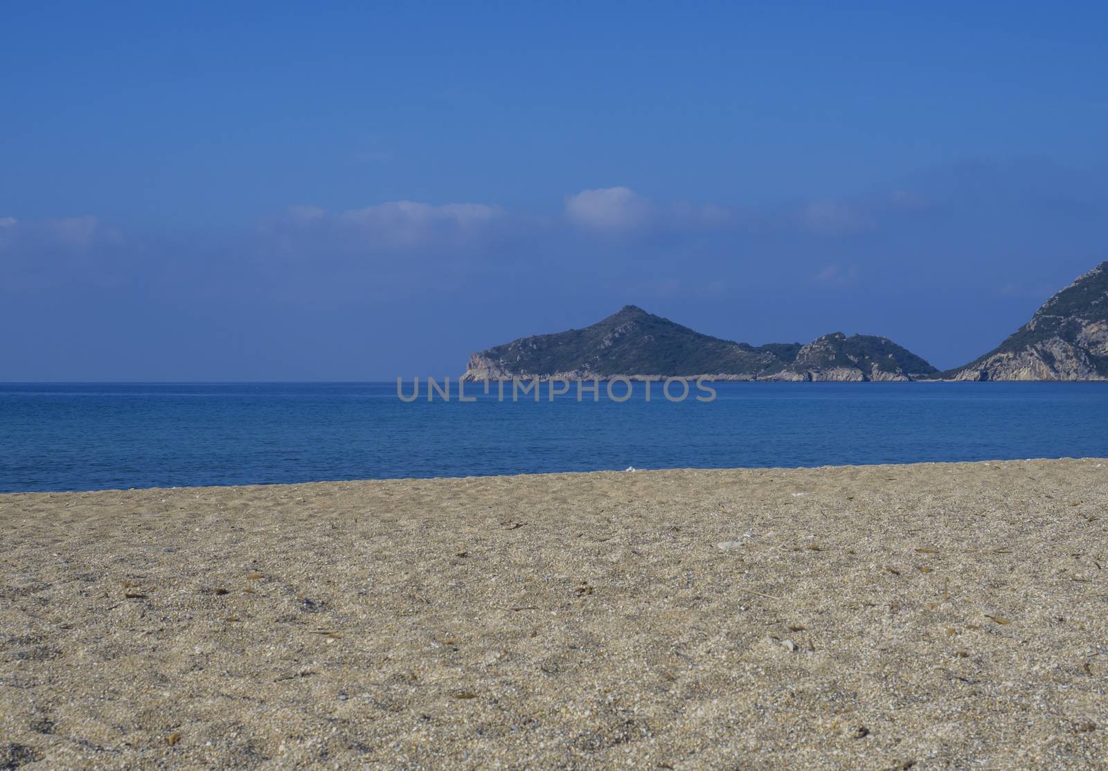Sand and pebbles beach and turquoise sea shore at Agios Georgios Pagon at Corfu island, Greece with view on porto timony bay.