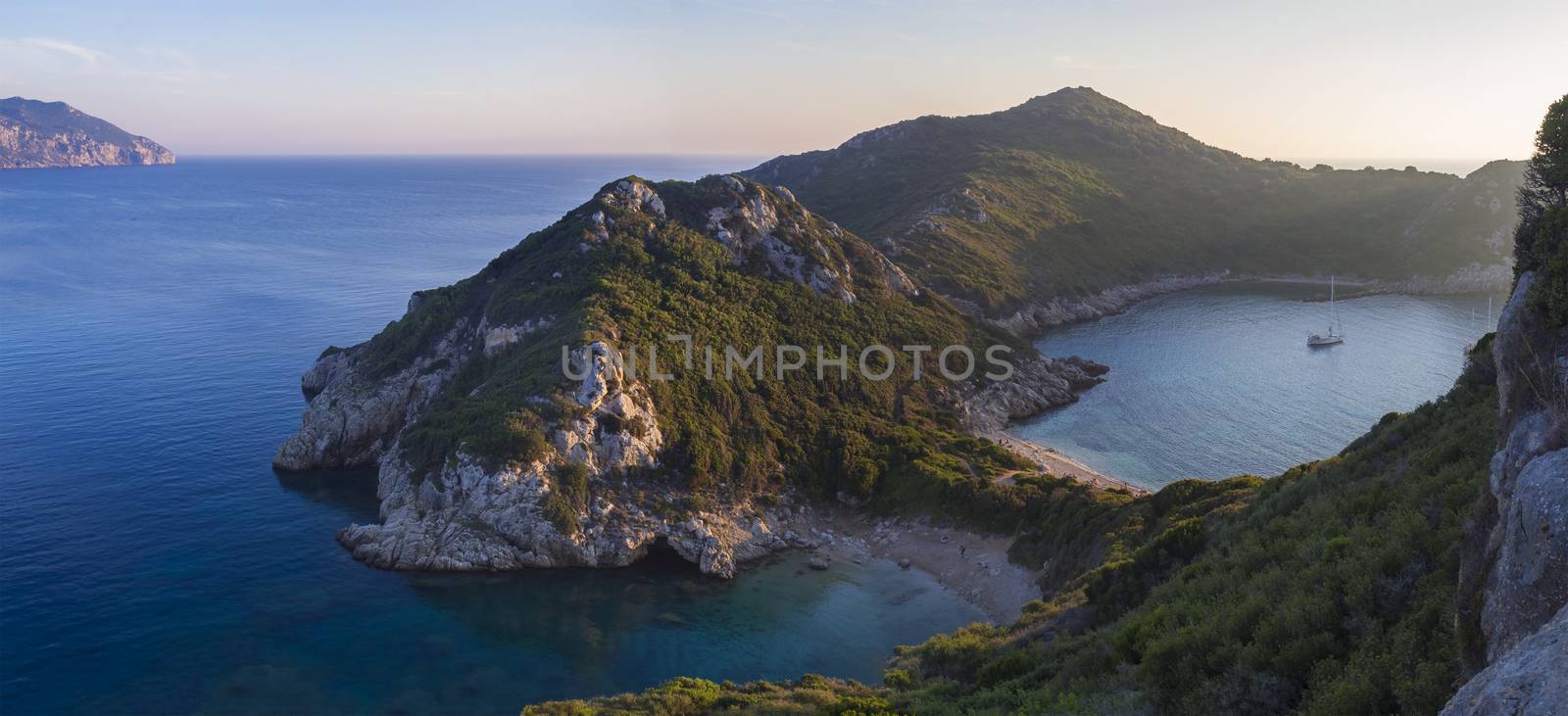 Corfu, Greece, Porto Timoni. View of the most famous double beach and bay in Afionas from the view point on the path. Sunset golden pink light.