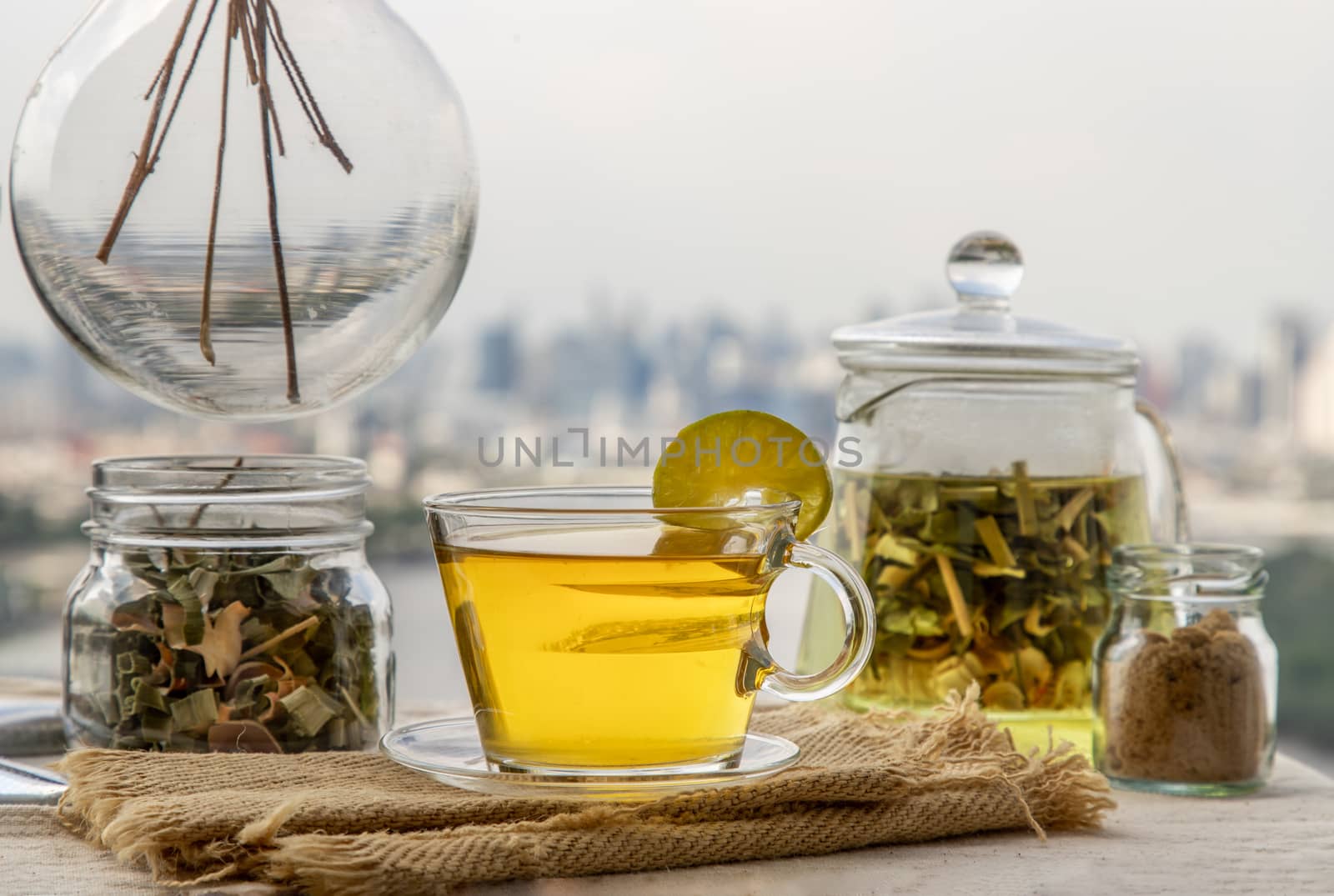 Refreshing and enjoy with A cup of lemongrass pandan tea served with brown sugar In the afternoon on beautiful city view. Thai herbal plant and healthy drinks concept. Selective focus, Copy space.