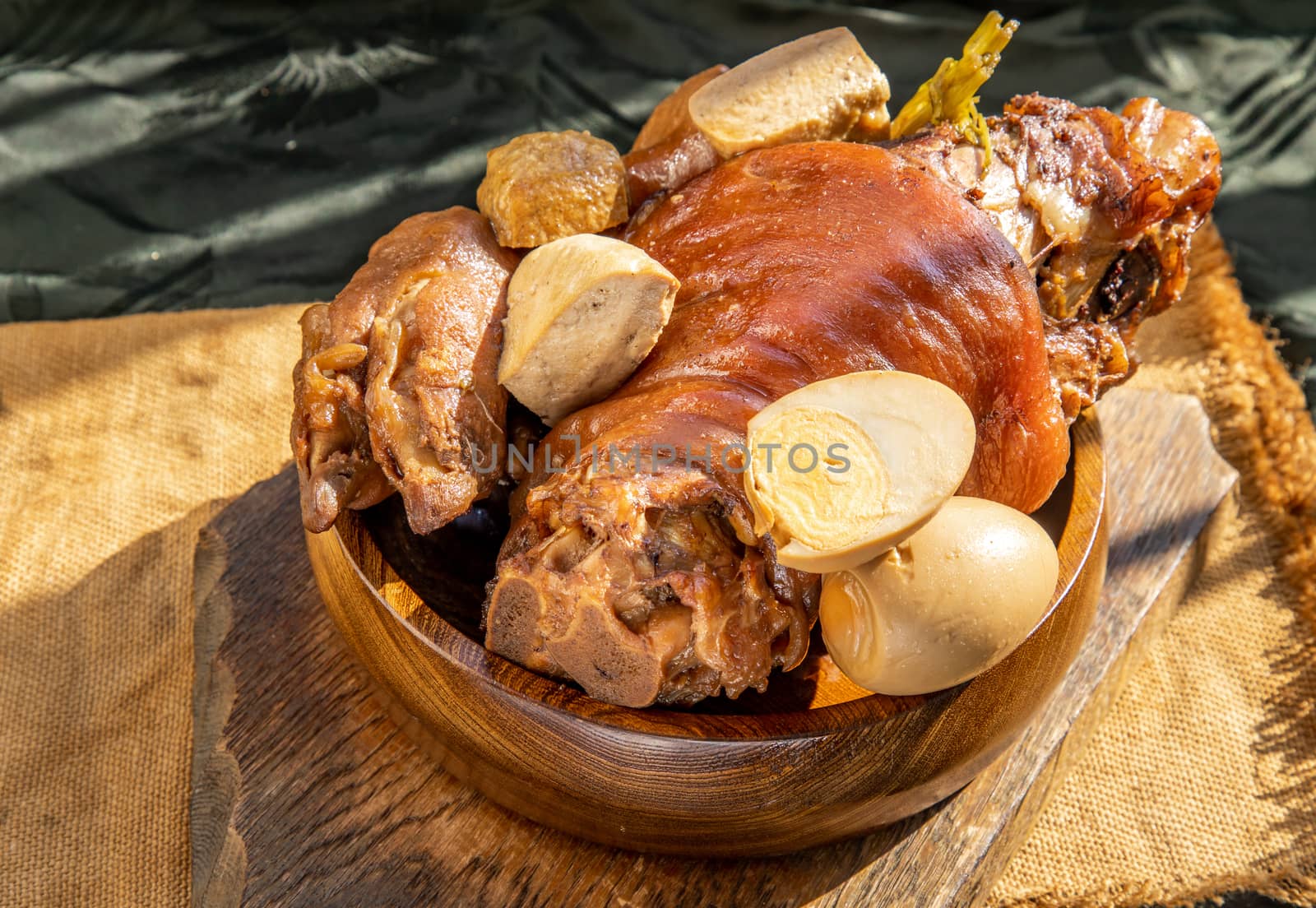 Chinese traditional dish stewed pork leg with boiling sweet gravy sauce and boiled egg with tofu. Selective focus.