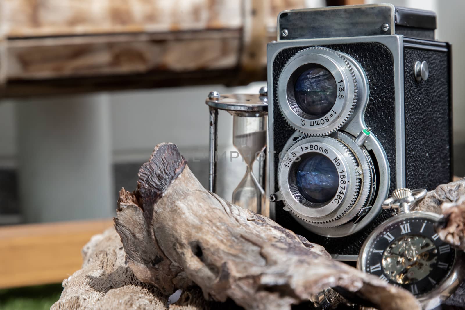 Vintage two lens photo camera with A retro pocket watch on wooden background. An idea of old camera and memory, time Nostalgia.