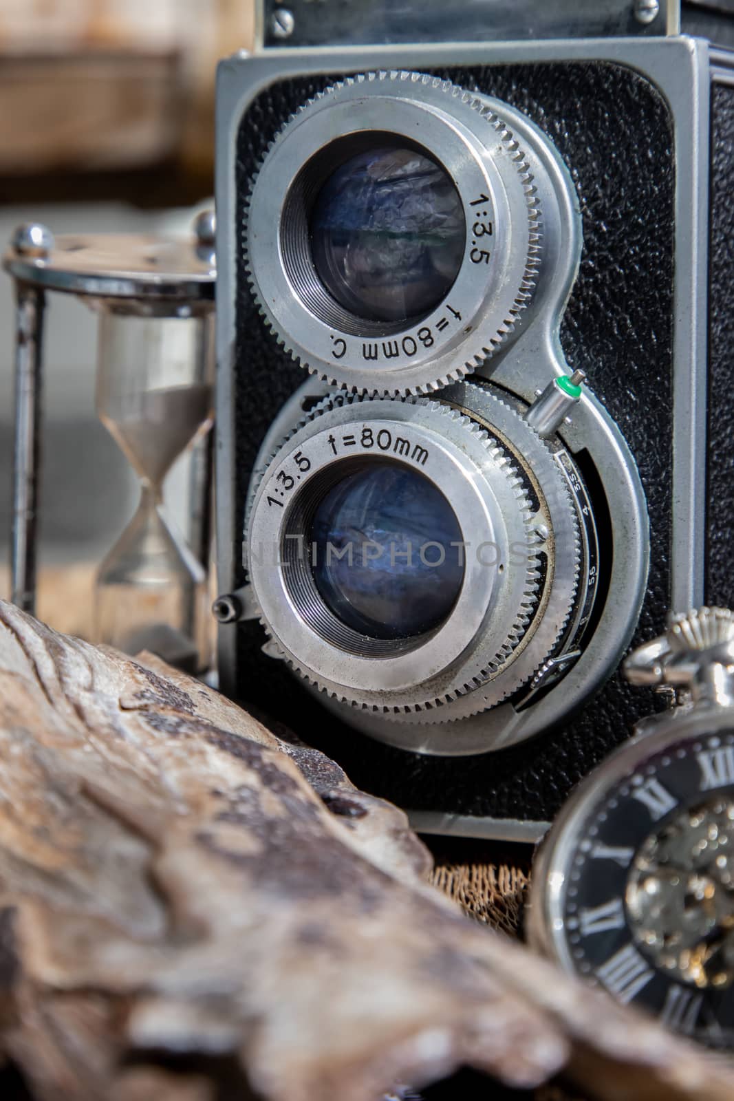 Vintage two lens photo camera with A retro pocket watch on wooden background. An idea of old camera and memory, time Nostalgia.