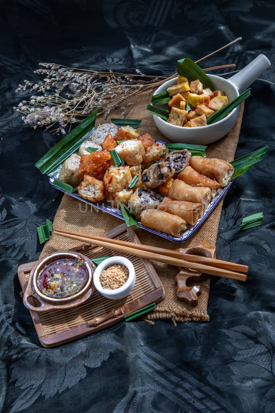Many vegetarian food : Fried taro rolls (Taro Guangjian) and Deep fried spring rolls, Fried tofu, Fried radish, Fried taro and black beans (Zhu jiao quan or Fried taro cakes) Served with spicy sweet sauce and roasted crushed peanuts with wooden chopsticks on Ceramic dishes. Selective focus.